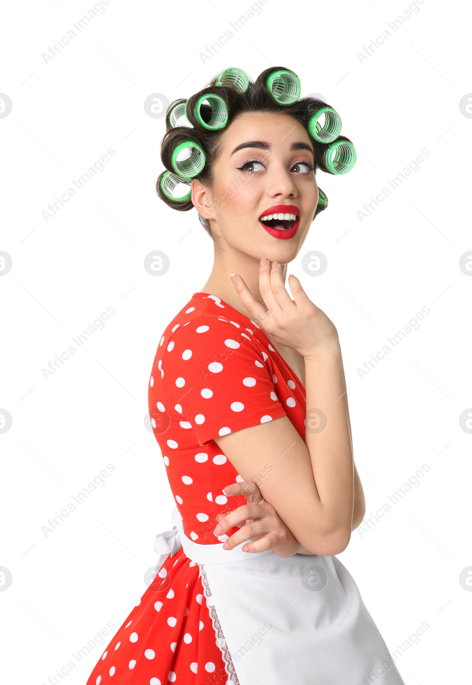Photo of Funny young housewife with hair rollers on white background