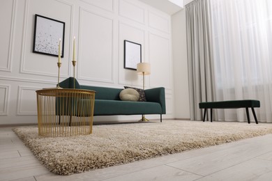 Photo of Stylish living room with soft beige carpet, coffee table and sofa. Interior design