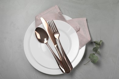 Photo of Stylish setting with elegant cutlery on grey table, top view