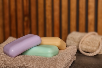 Photo of Towel with soap bars on table, closeup. Space for text