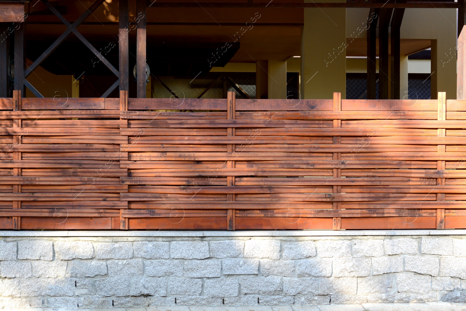 Photo of Wooden fence near house on sunny day outdoors