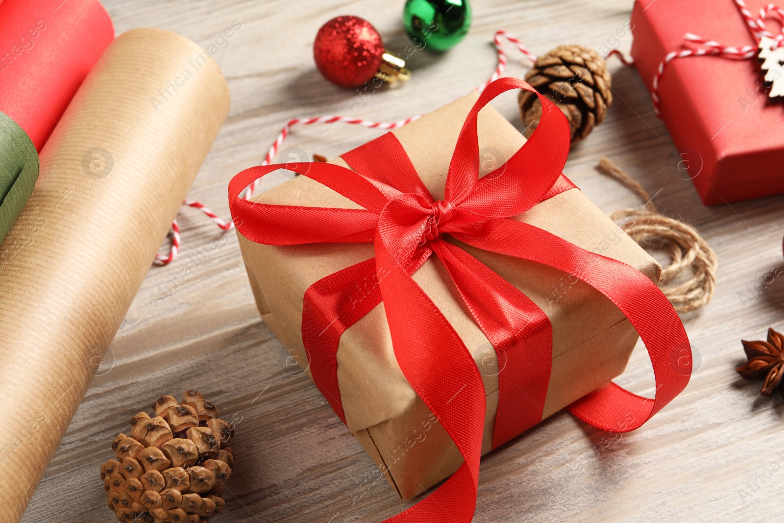 Photo of Beautiful gift box and Christmas decorations on white wooden table, closeup