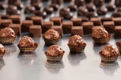 Many delicious chocolate candies on grey table. Production line