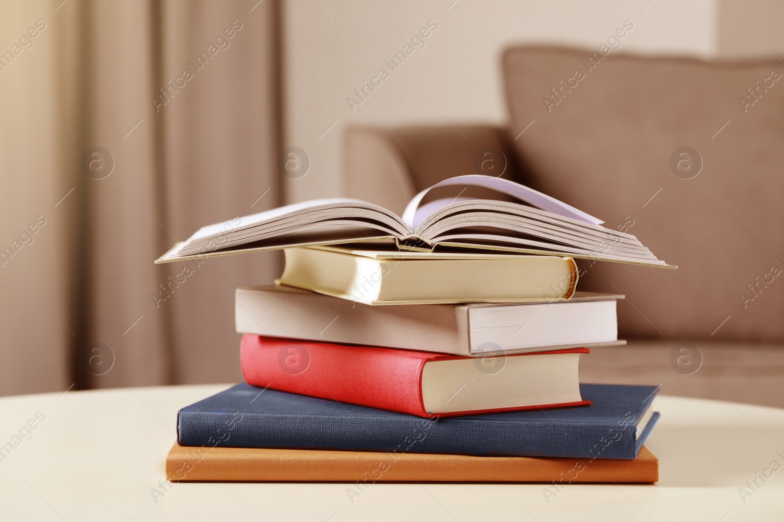 Image of Stack of hardcover books on white table indoors