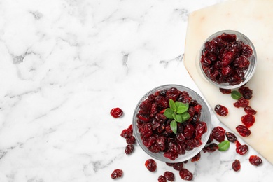 Photo of Flat lay composition with tasty dried cranberries on white marble table. Space for text