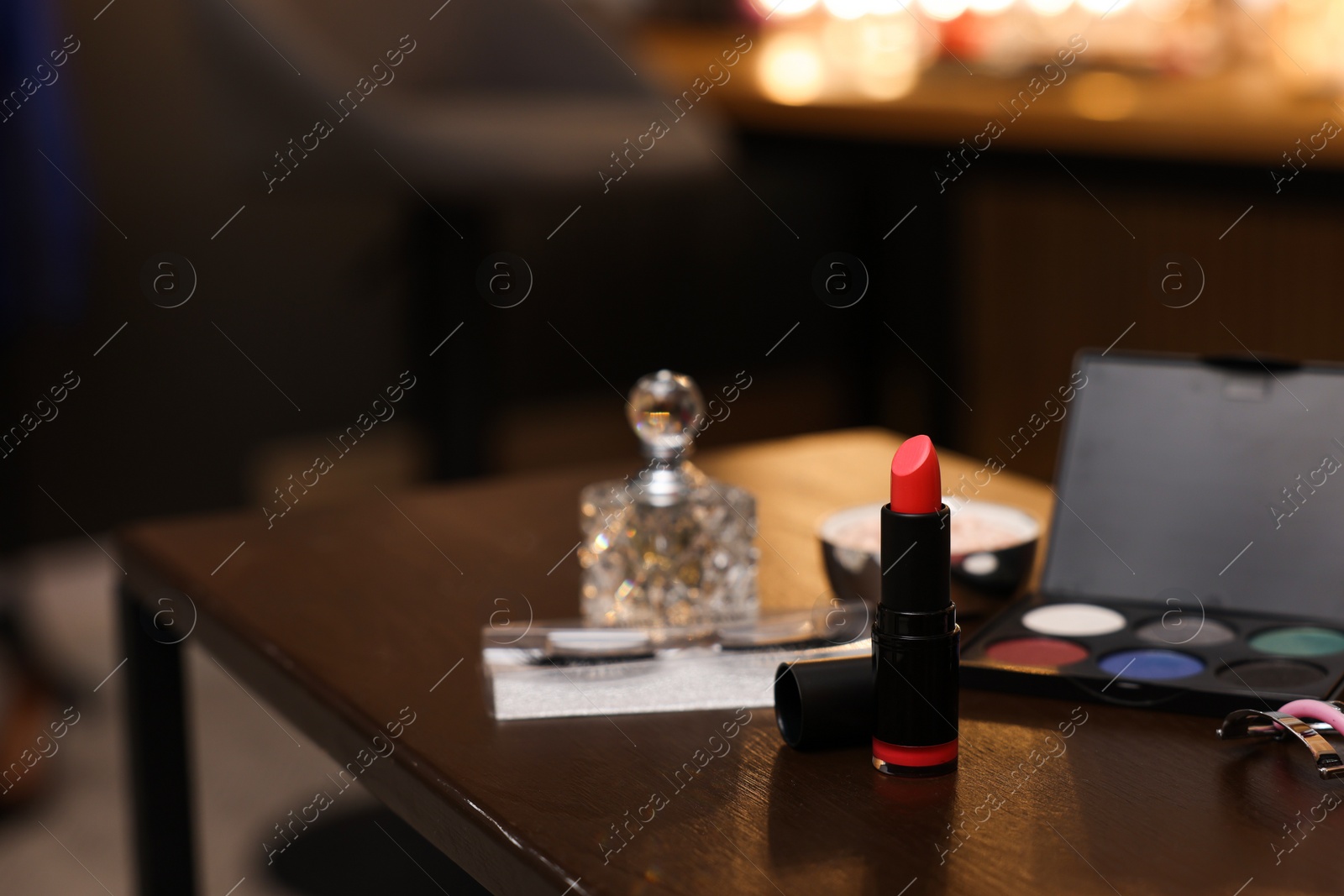 Photo of Red lipstick and other beauty products on wooden table. Makeup room