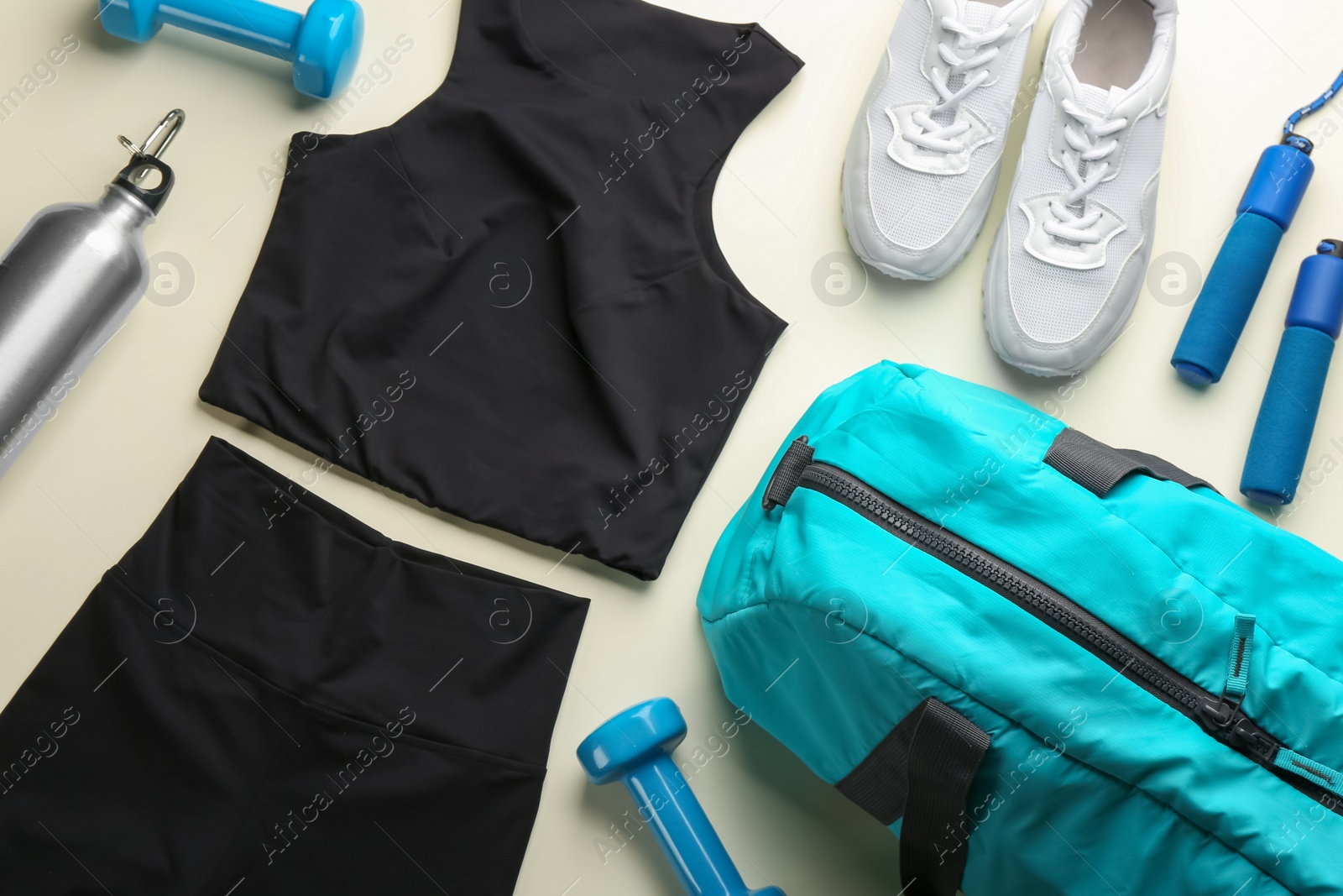 Photo of Flat lay composition with gym bag and sportswear on beige background