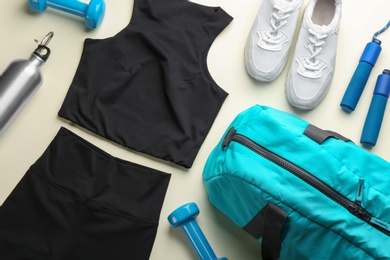 Photo of Flat lay composition with gym bag and sportswear on beige background