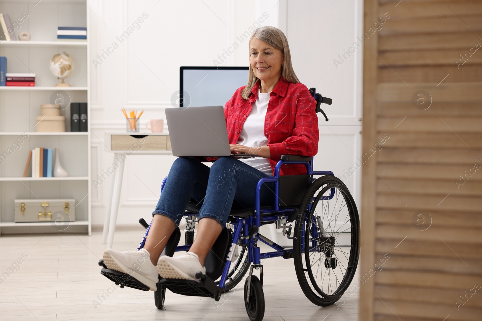 Photo of Woman in wheelchair using laptop at home