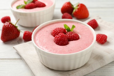 Delicious berry mousse with mint on white wooden table