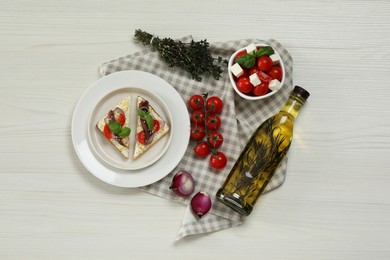 Flat lay composition with delicious anchovy sandwiches on white wooden table