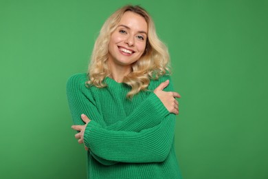 Photo of Happy woman in stylish warm sweater on green background