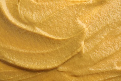 Photo of Fresh tasty mustard sauce as background, top view