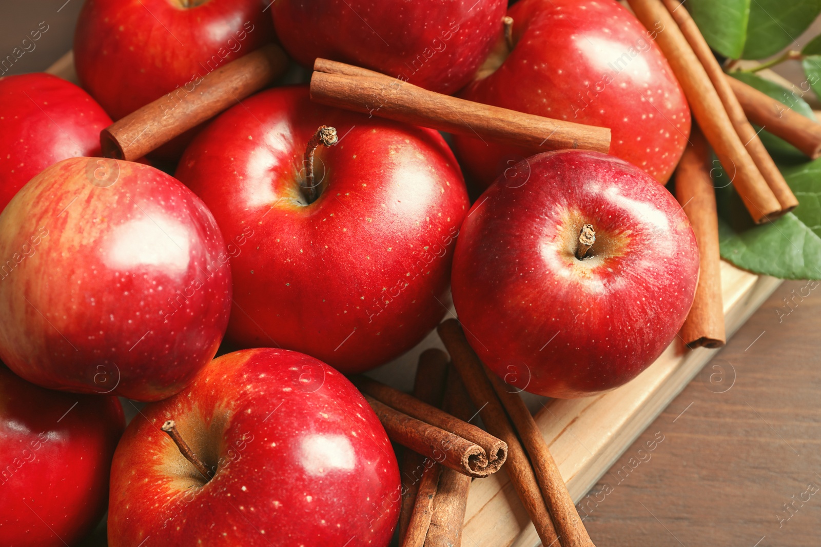 Photo of Fresh apples and cinnamon sticks, closeup