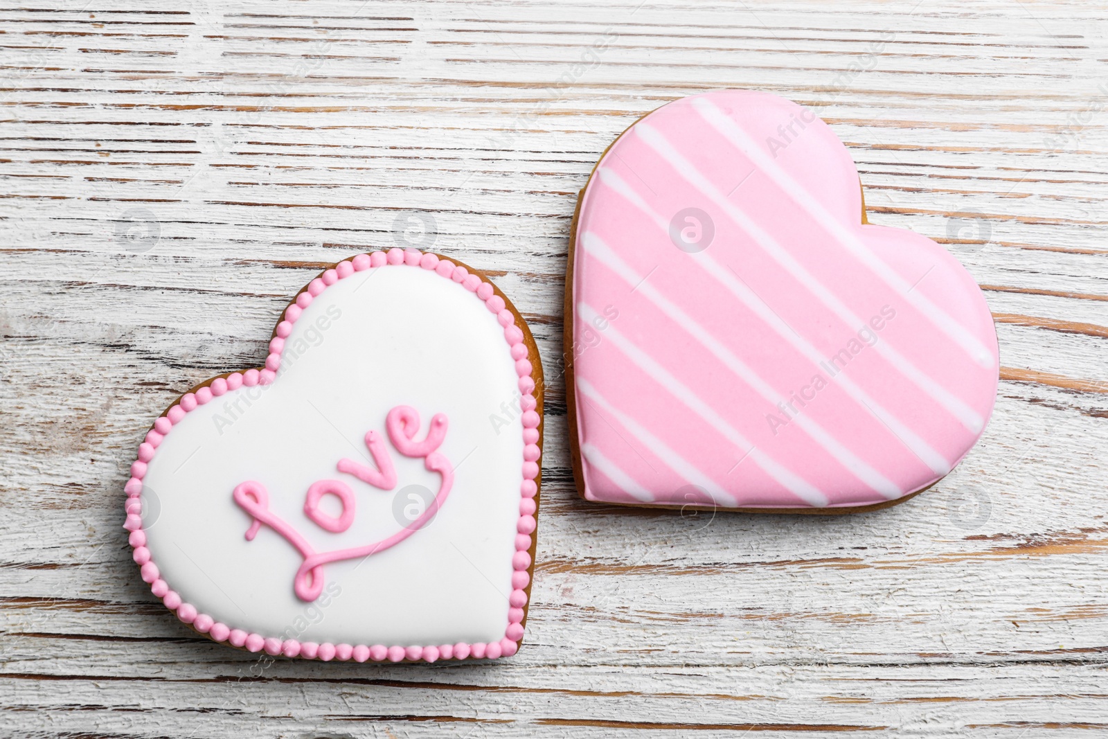 Photo of Heart shaped cookies on white wooden table, flat lay. Valentine's day treat