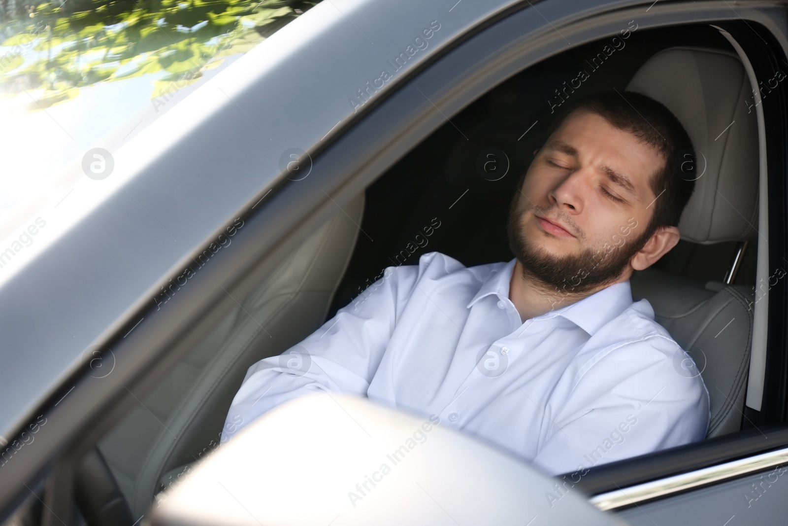 Photo of Tired man sleeping in his modern car