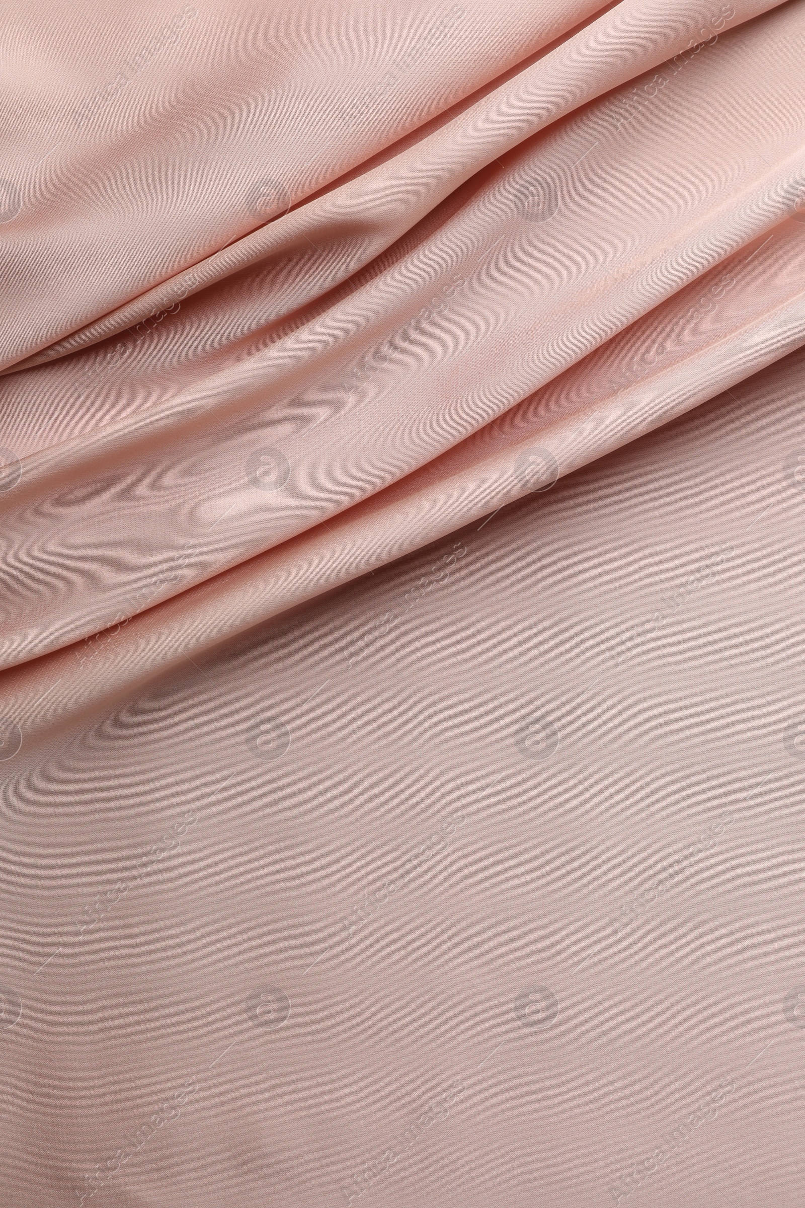 Photo of Crumpled pink silk fabric as background, top view. Space for text