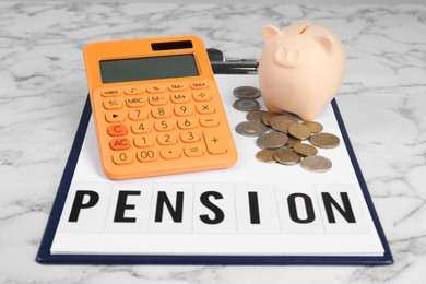 Photo of Calculator, piggy bank, coins and clipboard with word Pension on white marble table. Retirement concept