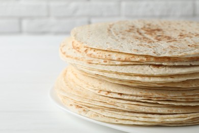 Stack of tasty homemade tortillas on white table