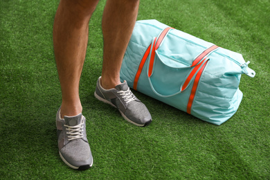 Photo of Man standing with sports bag, closeup view