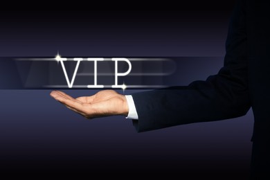 VIP member. Closeup view of man showing virtual abbreviation on dark background