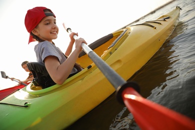 Photo of Little children kayaking on river. Summer camp activity