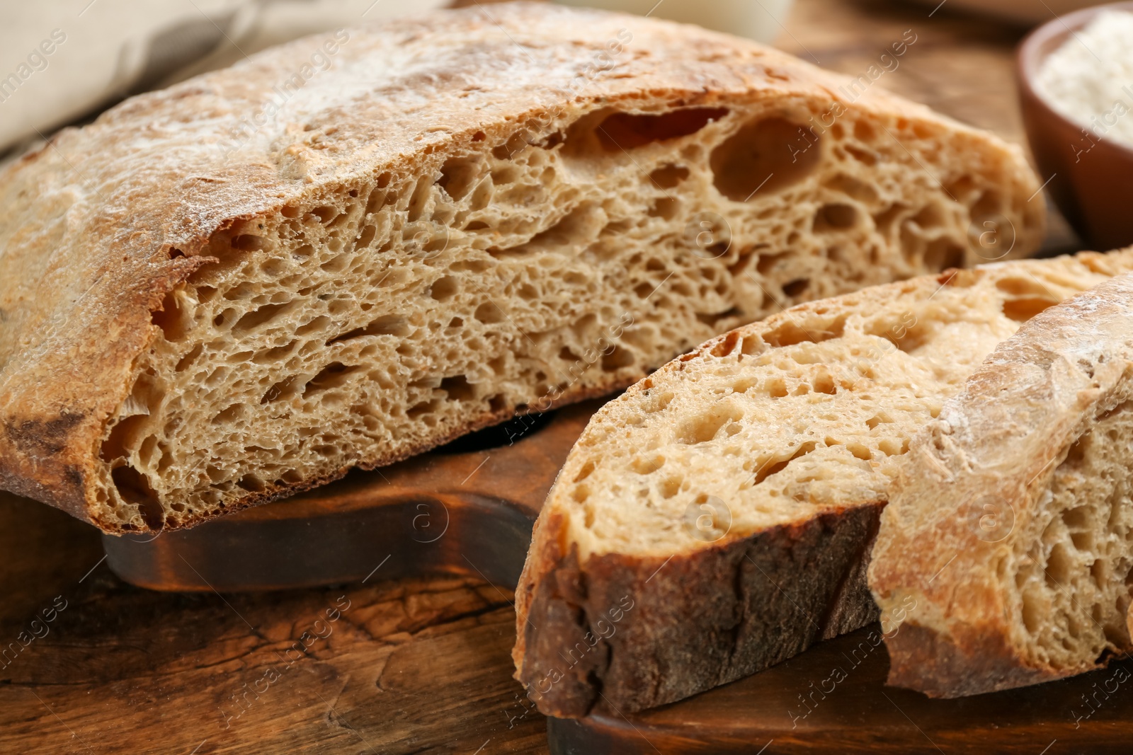 Photo of Tasty freshly baked bread on wooden table, closeup