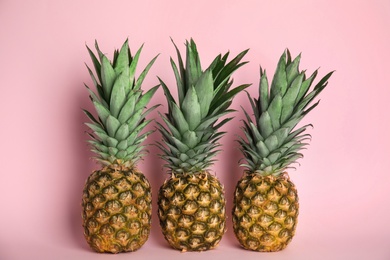 Photo of Whole ripe juicy pineapples on pink background