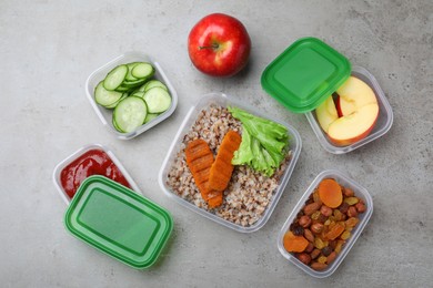 Set of plastic containers with fresh food on light grey table, flat lay