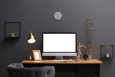 Modern computer on table in stylish office interior