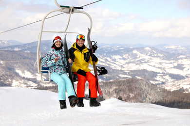 People using chairlift at mountain ski resort. Winter vacation