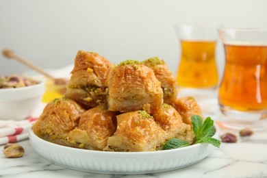 Delicious sweet baklava with mint on white marble table