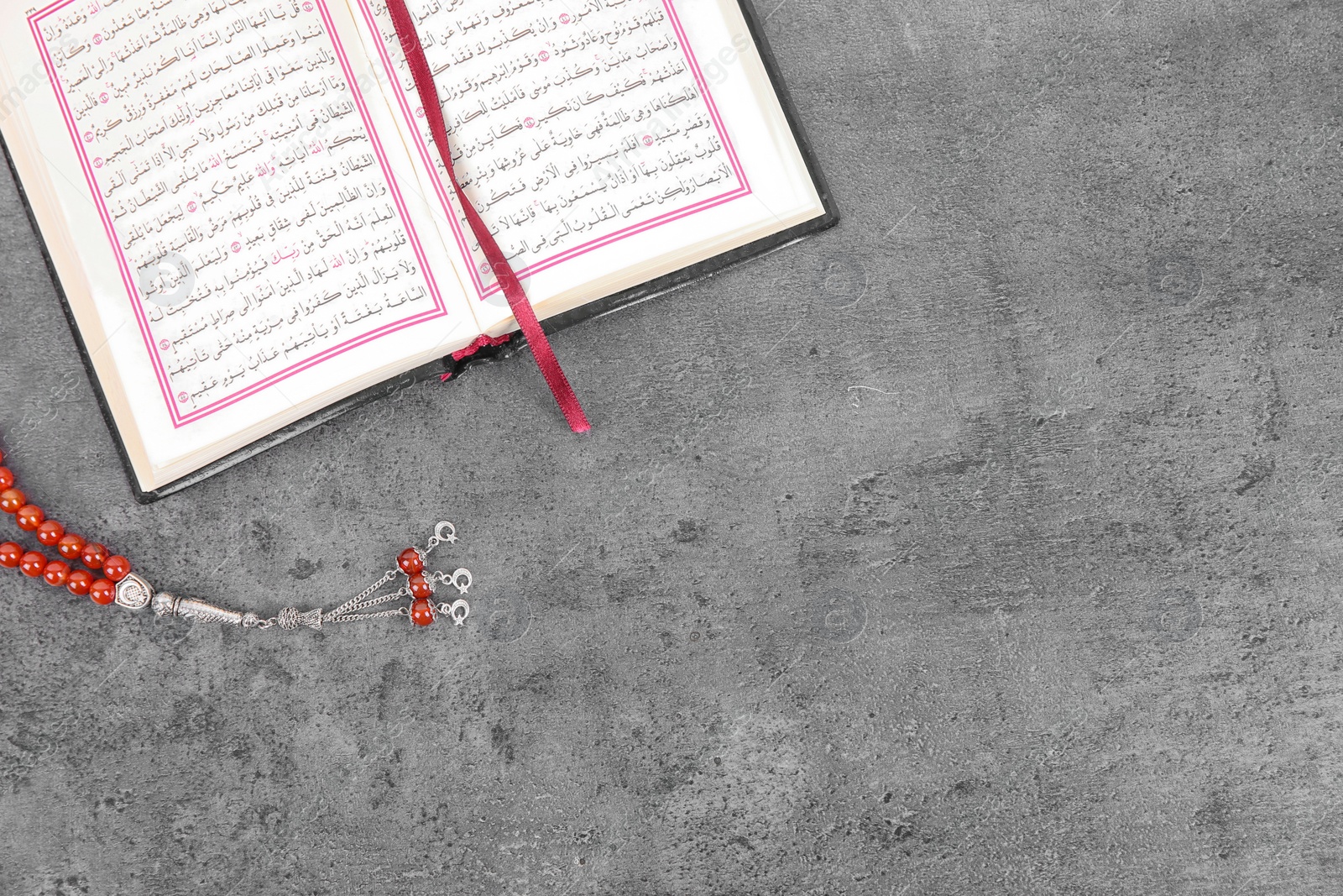 Photo of Muslim prayer beads, Quran and space for text on grey background, top view