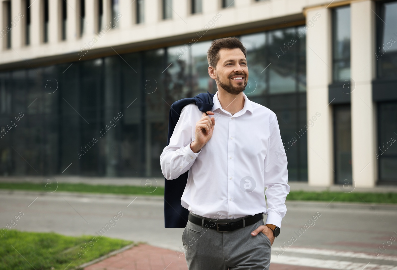 Photo of Handsome bearded businessman walking on city street