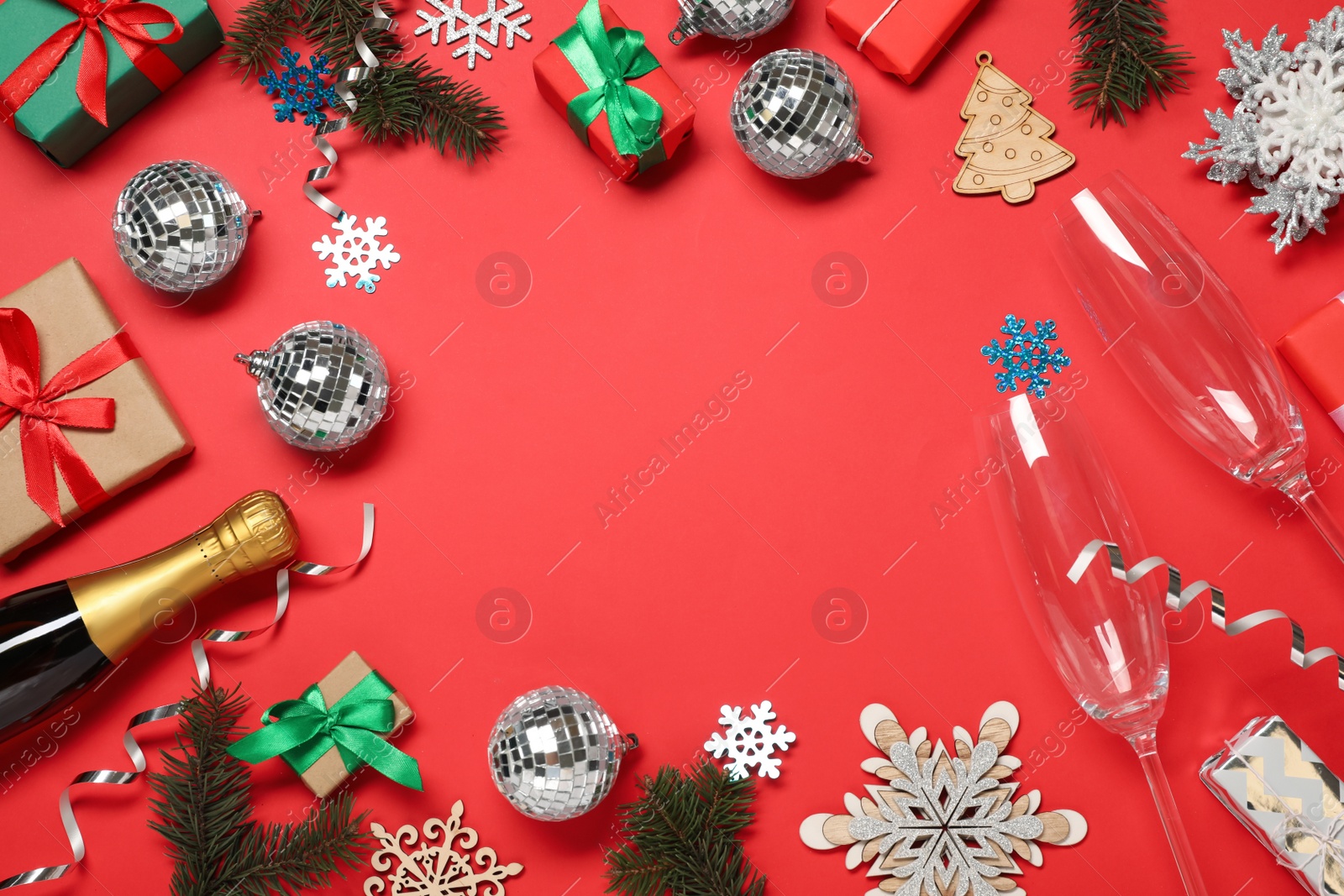 Photo of Frame of shiny disco balls and Christmas decor on red background, flat lay. Space for text