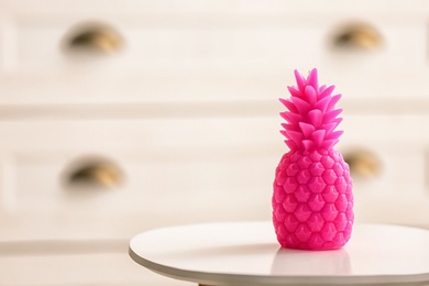 Stylish pineapple candle on table. Home decorating idea