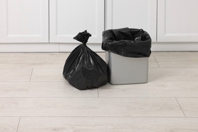 Photo of Plastic garbage bag and trash can indoors