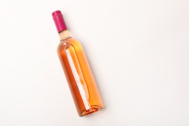 Photo of Bottle of expensive rose wine on white background, top view. Space for text
