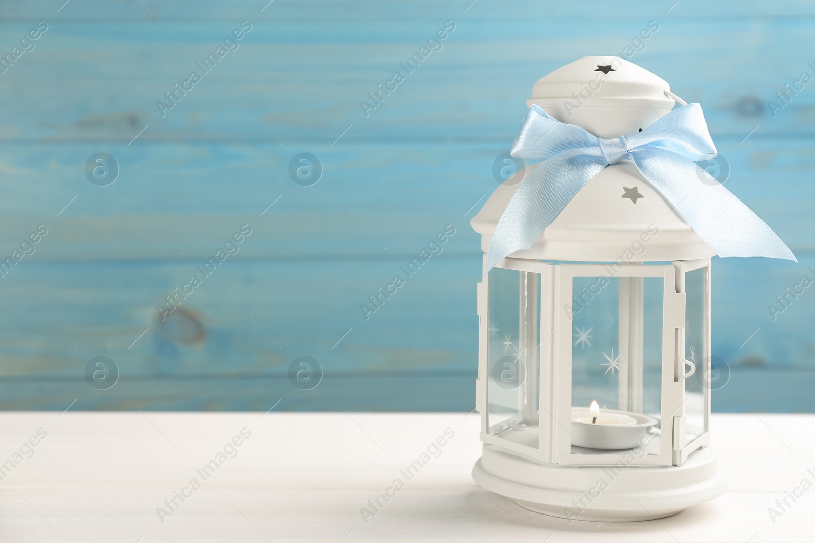 Photo of Beautiful decorative Christmas lantern with burning candle on white wooden table. Space for text