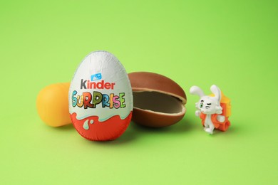 Photo of Sveti Vlas, Bulgaria - June 29, 2023: Kinder Surprise Eggs, plastic capsule and toy bunny on light green background