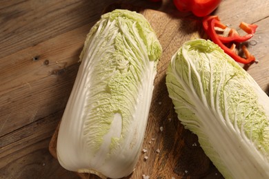 Fresh Chinese cabbages and bell peppers on wooden table, top view