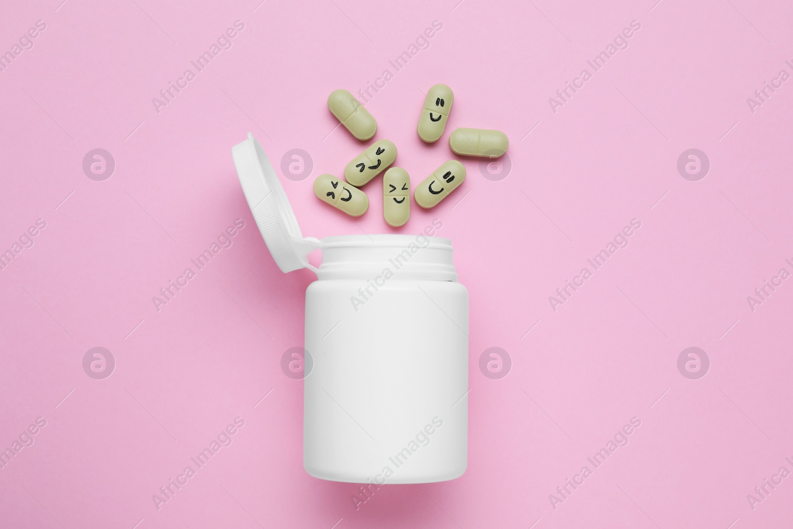 Photo of Bottle and antidepressant pills with funny faces on pink background, flat lay