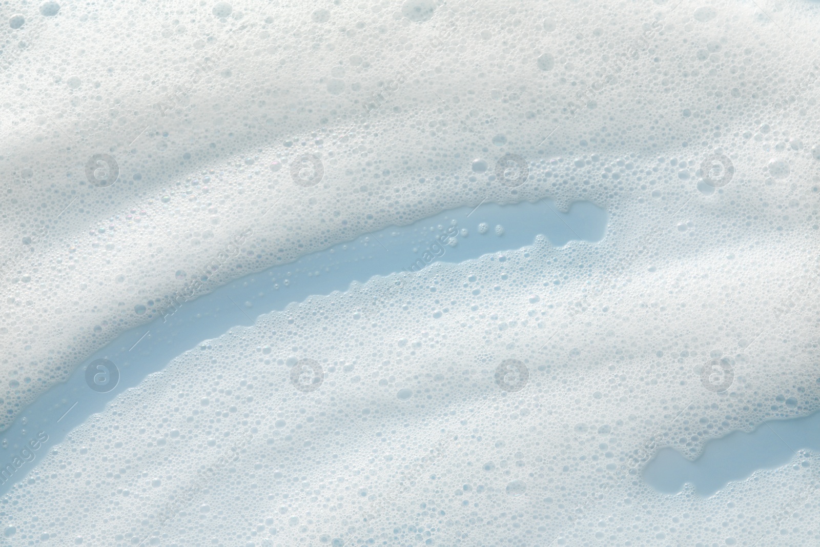 Photo of White washing foam on color background, top view