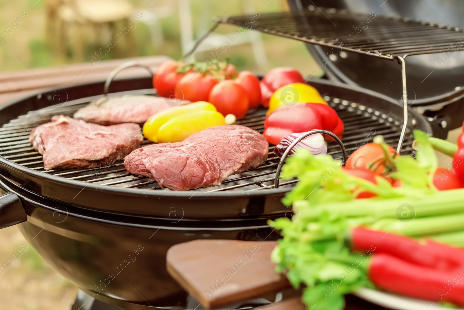 Photo of Modern grill with meat and vegetables outdoors, closeup