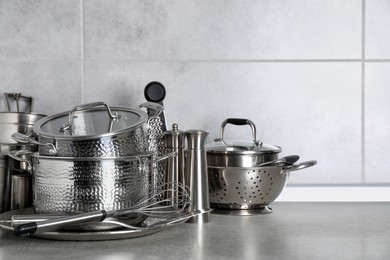 Photo of Set of different cooking utensils on grey countertop in kitchen