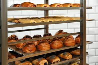 Photo of Rack with fresh pastries in bakery workshop