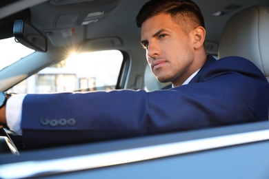 Photo of Handsome man in his modern car, view from outside