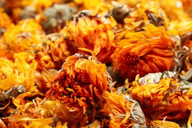 Photo of Pile of dry calendula flowers as background, closeup
