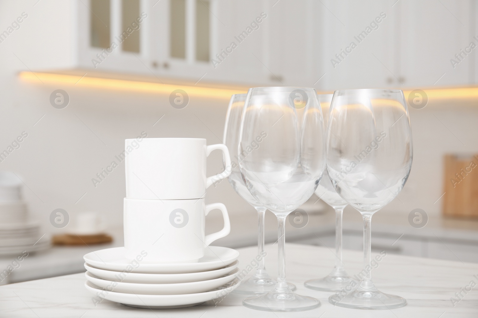 Photo of Set of clean dishes on table in stylish kitchen