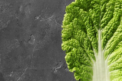 Fresh Chinese cabbage leaf on gray textured table, top view. Space for text